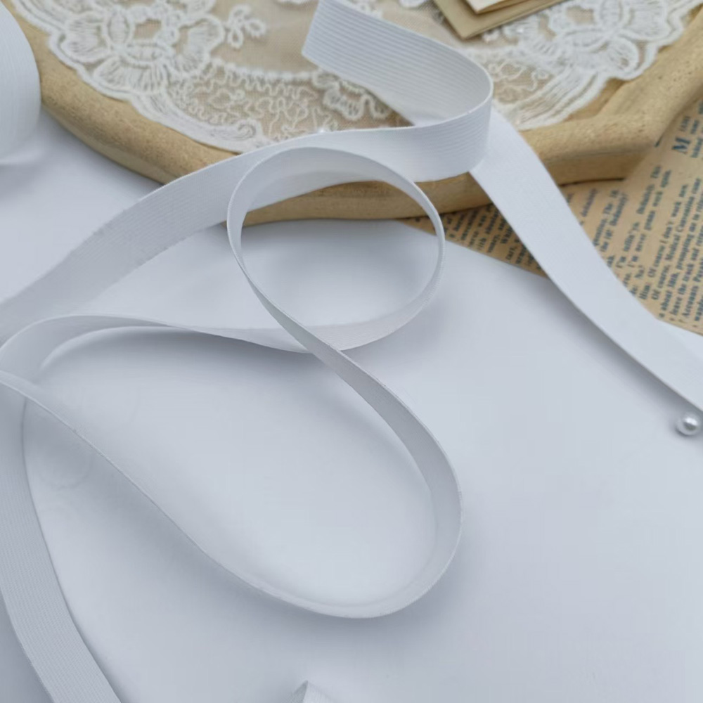 White crochet-knit elastic band coiled in a loop showing flexibility