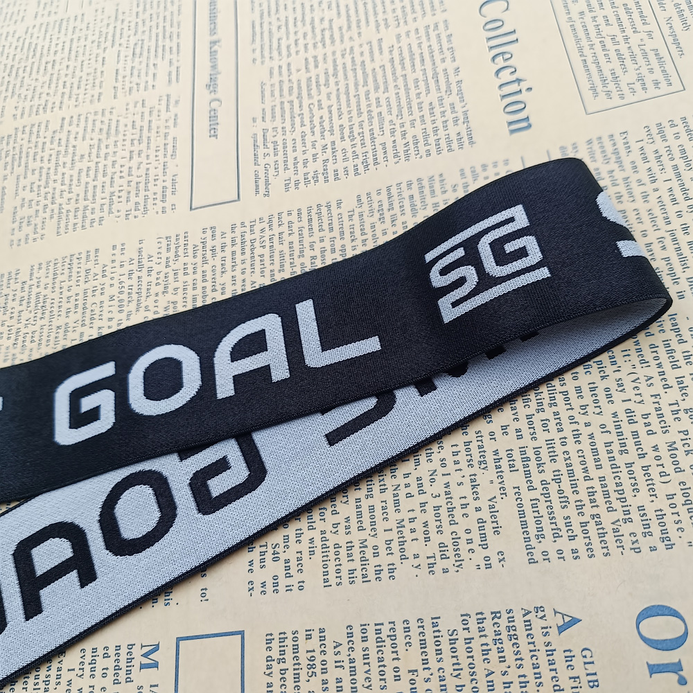 Roll of dark navy jacquard elastic band with woven light-coloured lettering for men's underwear waistbands