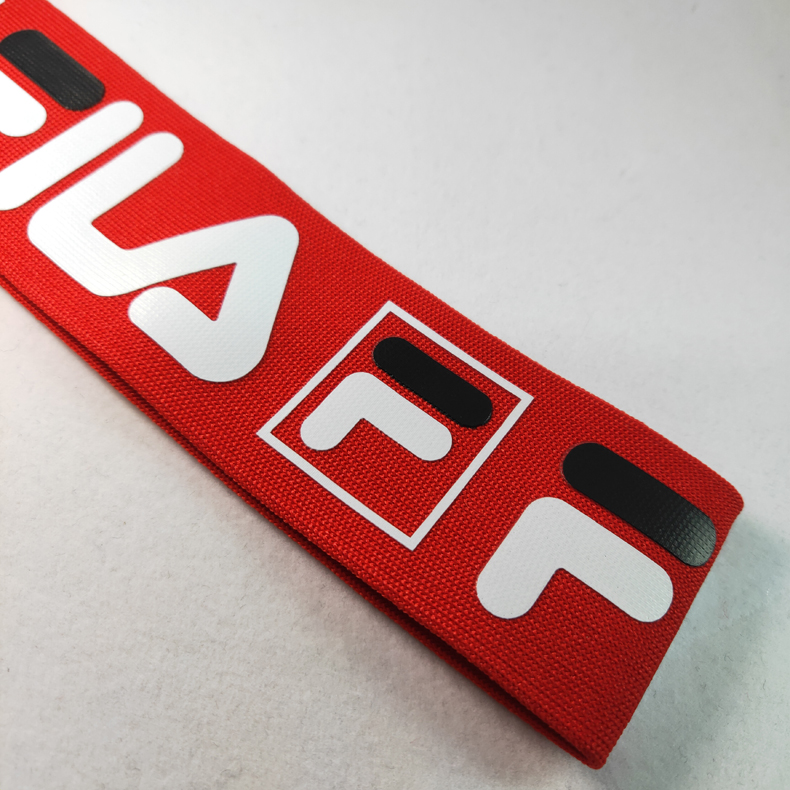 Red knitted polyester webbing with printed white and black logo graphics