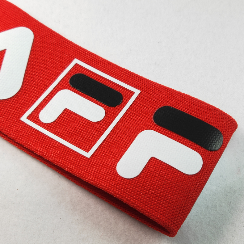 Close view of printed logo detail on red polyester knitted webbing