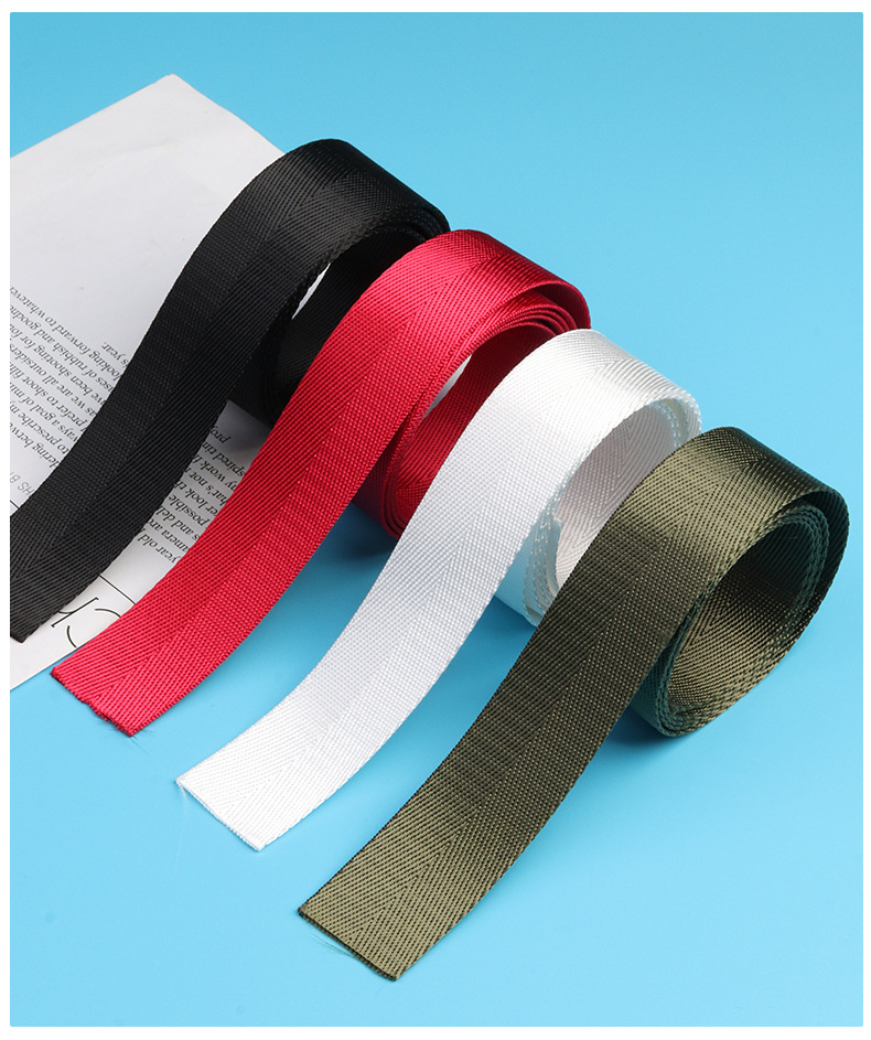 Four rolls of herringbone webbing in black, red, white and army green